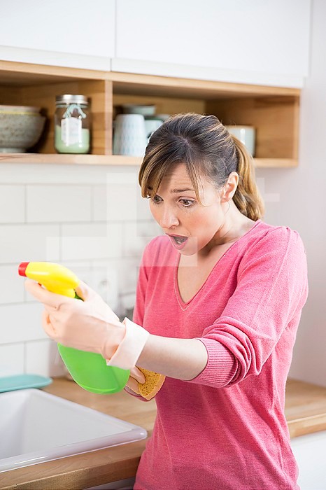 Woman using a conventional cleaning product.