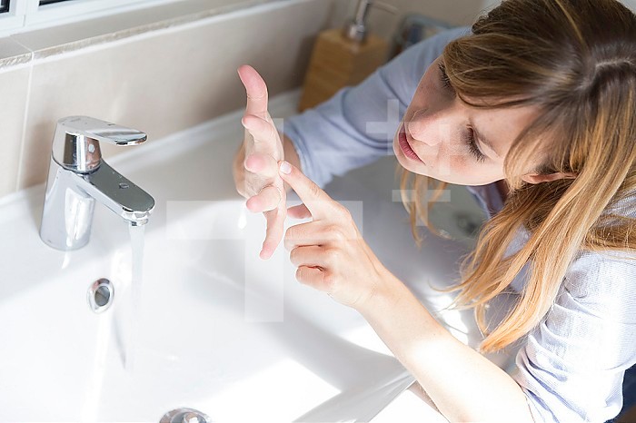 A woman suffering from contamination OCD: obsessive hand washing.