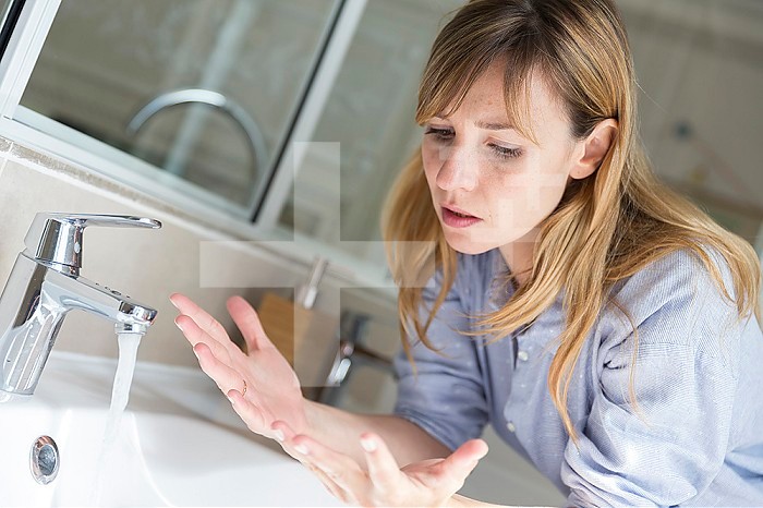 A woman suffering from contamination OCD: obsessive hand washing.
