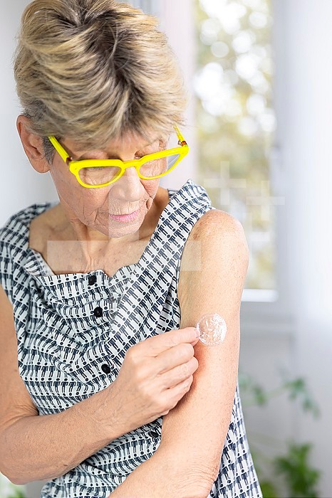 Woman applying post-menopause hormone gel.