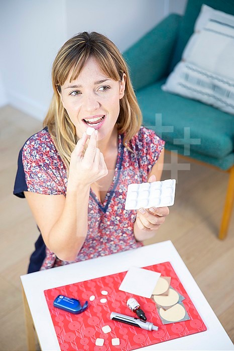 A woman taking a lozenge as a nicotine substitute.