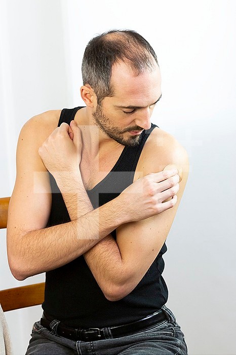 A man putting a nicotine patch on.