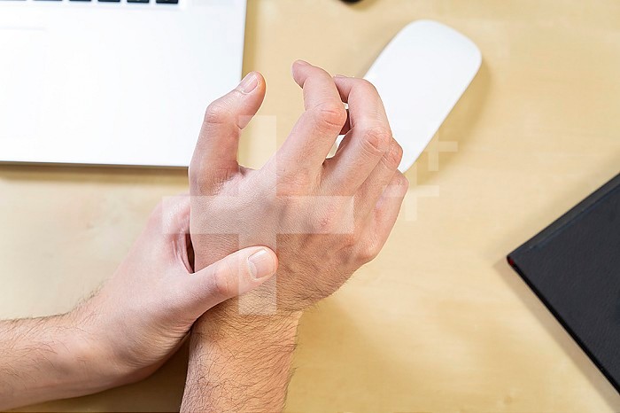 Close-up of a man´s hand experiencing pain due to prolonged use of the mouse.