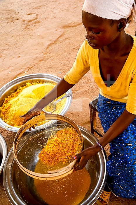 Girl making flour in Koudougou, Burkina Faso.