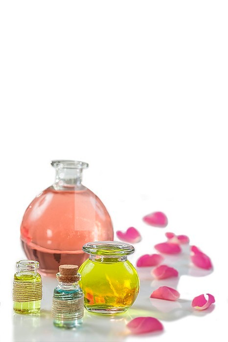 Rose flower petals with aromatherapy essential oil glass bottle isolated on white , background, copy-space