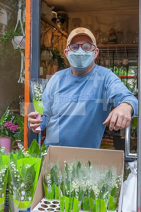 Florist authorized to sell lily of the valley for delivery or take out in front of his store, Paris, 75011, France, Europe.