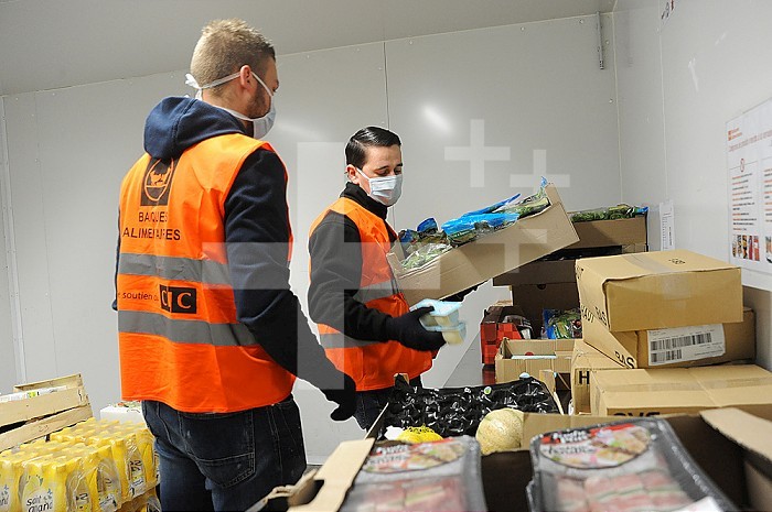 Report Food Bank of North - Lille. Since the start of the Covid 19 health crisis, the association has been ensuring the daily distribution of foodstuffs to partner associations. The employees ensure by respecting the barrier gestures the supply to cover the increasing food aid needs. Every day according to a protocol implemented since the confinement of tons of fresh products, frozen, canned, milk, potatoes. .are distributed. Associations receive a donation to enable them to help people in difficulty. Employees in the warehouse who respect social distancing measures. Sorting of fresh products.