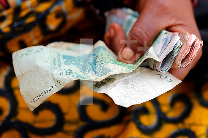 Woman using CFA Francs. Banknotes. Close-up. Lome. Togo.