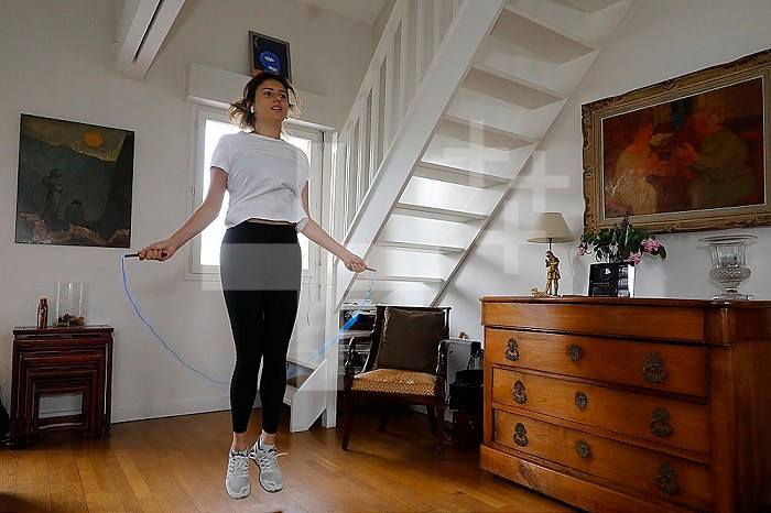 Young woman exercising at home during lockdown in Montrouge, France.