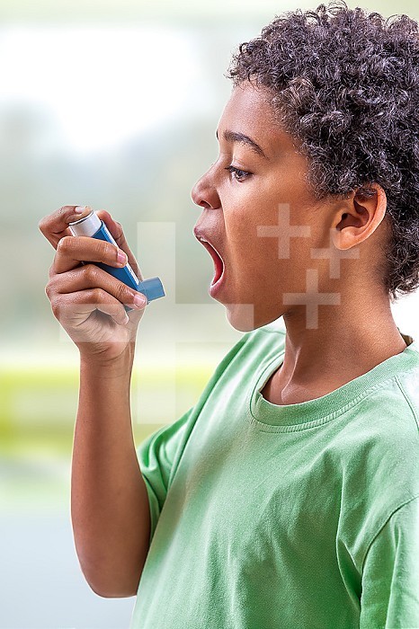 Close-up portrait of cute 5 year old boy using his asthma inhaler