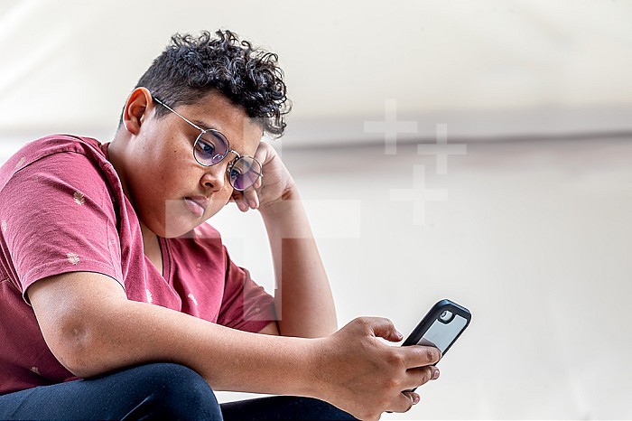 Young mixed race boy with his cell phone