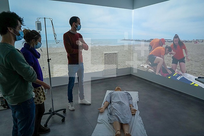 Emergency medicine students attends a circumstantial emergency simulation course led by two emergency physicians. Simulation of a drowning case at the beach. Realistic images and sound are projected all around the room to immerse students in total immersion. A young girl came up to the water´s edge in cardiac arrest.