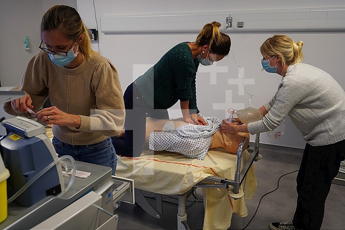 Resuscitation training on a dummy: cardiac massage and respiratory support. Various health professionals are trained in the evolution of practices, care and emergency procedures within the Faculty of Medicine of Montpellier. They must work on serious cases of daily life faithfully reproduced on a SimMan dummy. Here, respiratory arrest on a man in his forties. Attempt at resuscitation using a defibrillator, AED, cardiac massage and respiratory assistance.