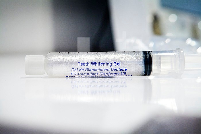 Teeth whitening by applying a gel in a tray and exposure to an LED lamp.