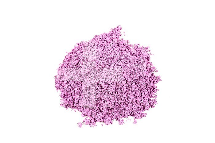Heap of superfine purple clay on white background.