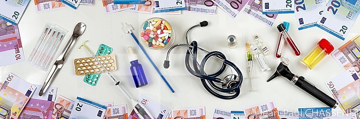 Banknotes around medicines and medical equipment.