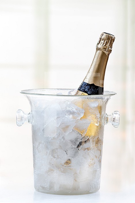 Bottle of champagne in an ice bucket.