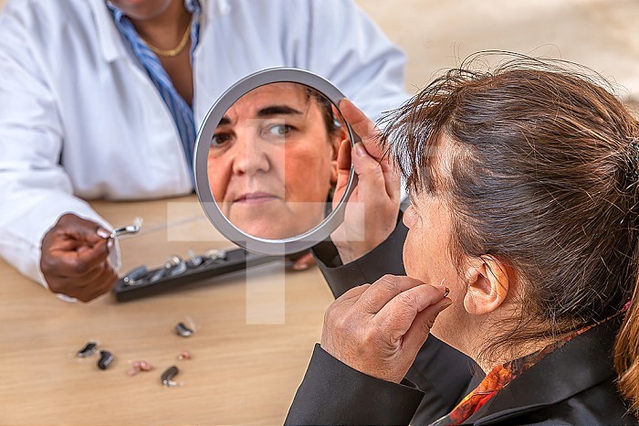 Patient trying different types of hearing aids.