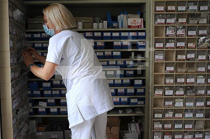 A nurse prepares medicine in a hospital pharmacy.