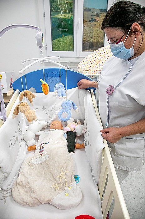 Educational room in which the nurse explains to the parents which are the good and bad products to use for their baby. Here to avoid, blanket surrounding the baby, mobile, too many comforters, stuffed animals, preventing air from circulating around baby.