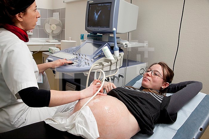 Midwife performing a prenatal ultrasound. 39 1/2 weeks pregnant woman.