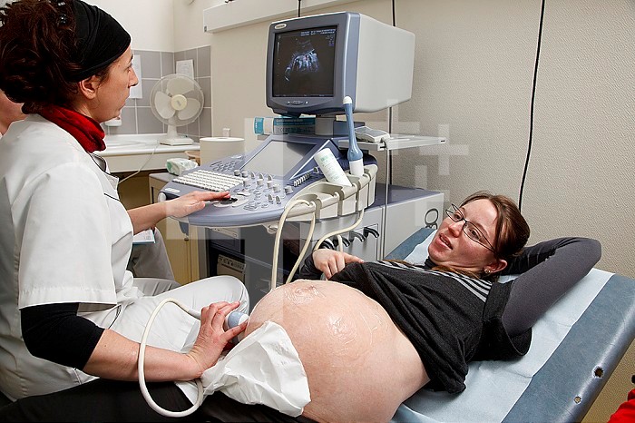 Midwife performing a prenatal ultrasound. 39 1/2 weeks pregnant woman.
