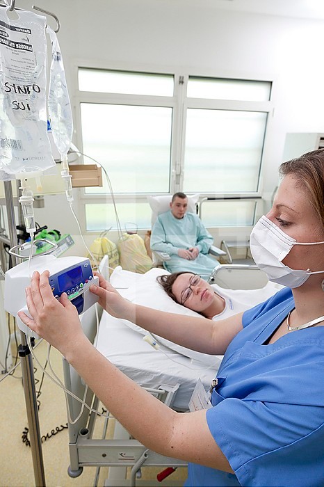 Infusion of oxytocin / syntocinon accelerating contractions. Labor in the delivery room can sometimes last several hours. Midwife adjusting the flow rate of the infusion.