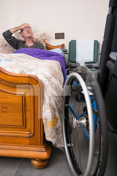 ADMR 62 - Home Help in Rural Areas, Pas de Calais. Muriel, Auxiliary of Social Life (AVS) works at the home of Mr. T. who is severely handicapped by Multiple Sclerosis. Muriel must help her with all the daily tasks. Disabled person in bed with wheelchair nearby.