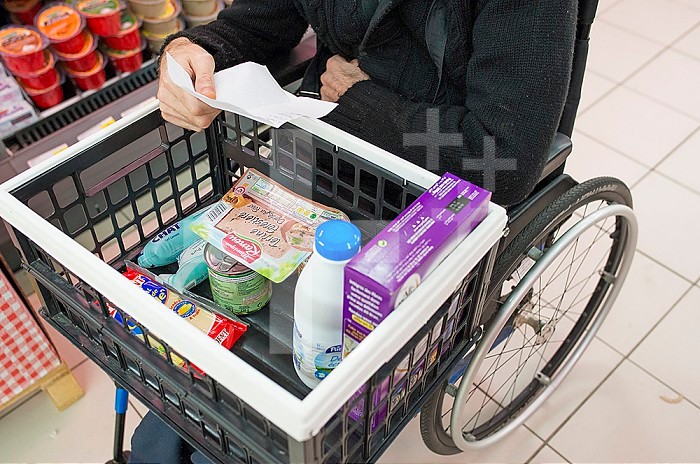 ADMR 62 - Home Help in Rural Areas, Pas de Calais. Veronique, Auxiliary of Social Life (AVS) works at the home of Mr. T. who is severely handicapped by Multiple Sclerosis. Carer accompanying a disabled person on the shelves of a supermarket to help him with his weekly shopping.