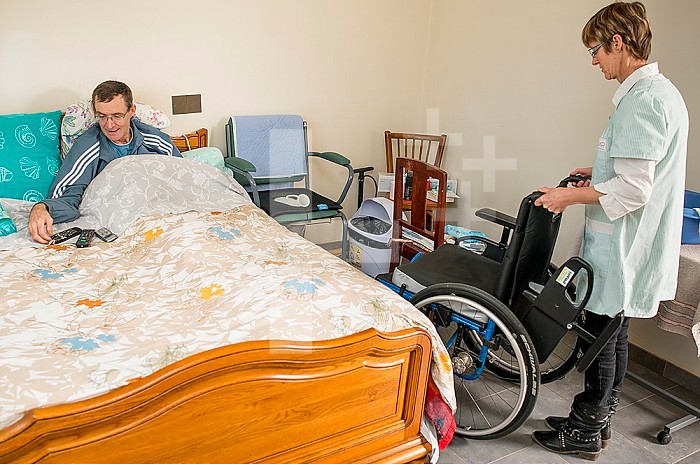 ADMR 62 - Home Help in Rural Areas, Pas de Calais. Muriel, Auxiliary of Social Life (AVS) works at the home of Mr. T. who is severely handicapped by Multiple Sclerosis. Muriel must help her with all the daily tasks. Carer and disabled person bedridden in his bedroom.