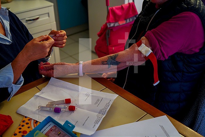 Freelance nurse taking a blood sample from a patient.