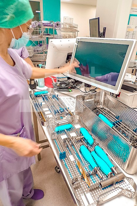 Operator preparing to fill an instrument with the help of the computer for sterilization.