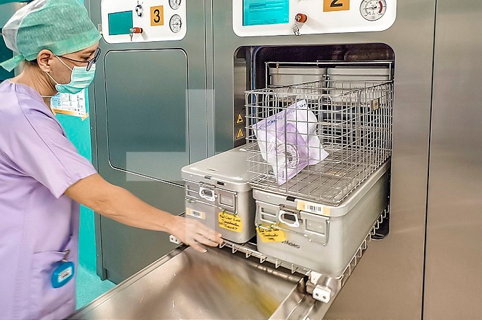 Operator inserting the material to be sterilized into the autoclave sterilizer.