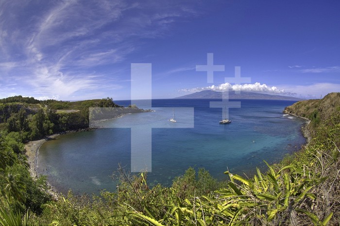 Sailboats and snorkelers in Honolua Bay, Maui, Hawaii, USA.  The eastern end of the island of Molokai is in the background.