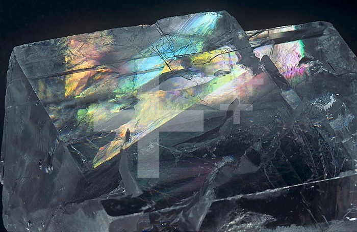 Calcite crystal showing spectral colors caused by birefringence or double refraction, Iceland.
