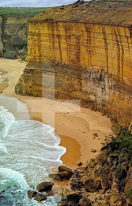 Soft limestone strata being eroded by waves. Note the rocks that have fallen from the cliff wall. Port Campbell National Park, Victoria, Australia.