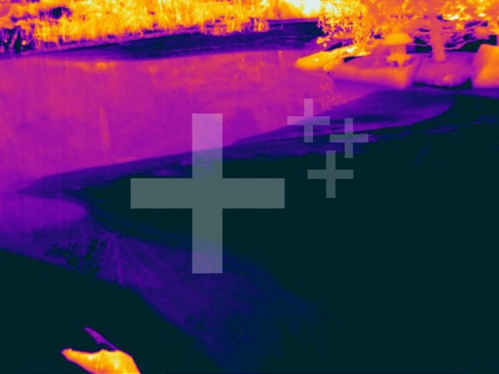 Thermogram of a pond showing melting ice. Black is ice and pink is open water. The colors show temperature variation with the temperature scale running from white (warmest) through yellow, orange, red, purple and black (coldest).