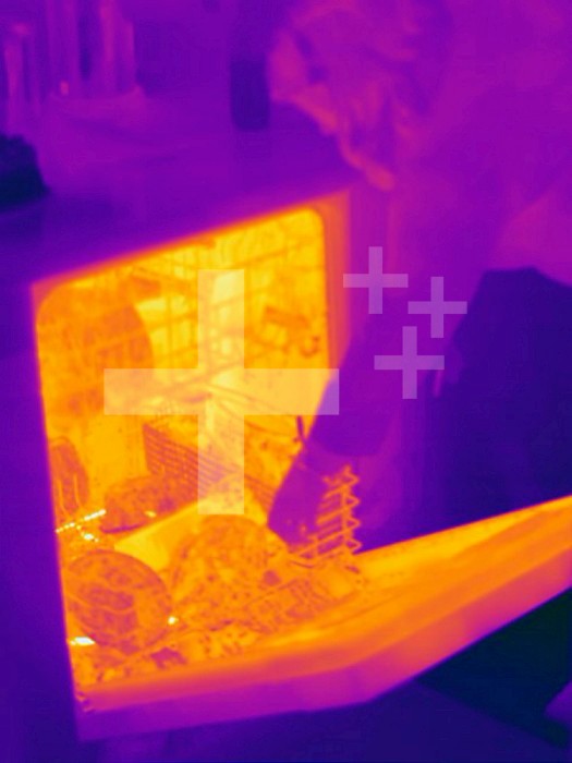 Thermogram - Dishwasher after wash cycle - The colors show temperature variation. The temperature scale runs from white (warmest) through yellow, orange, red, purple and black (coldest)