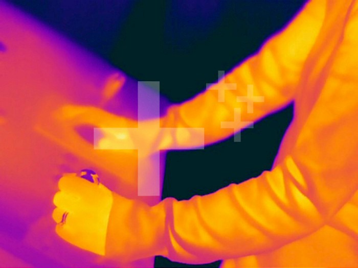 Thermogram - Female playing arcade game - The colors show temperature variation. The temperature scale runs from white (warmest) through yellow, orange, red, purple and black (coldest)