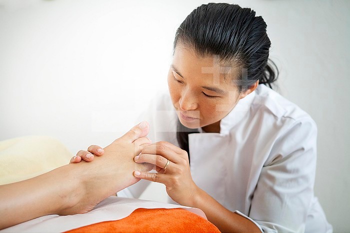 Reportage in a naturopath’s practice in France. Foot reflexology session.