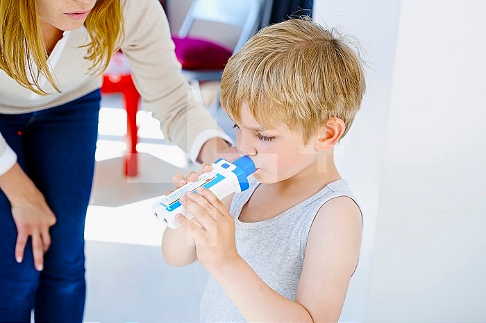 5-year-old boy breathing into a spirometer.
