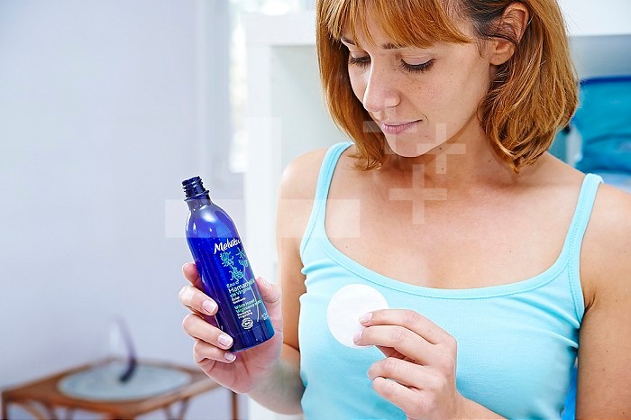Woman using witch hazel floral water.