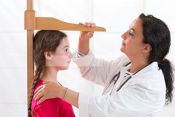 Doctor measuring the height of a girl.