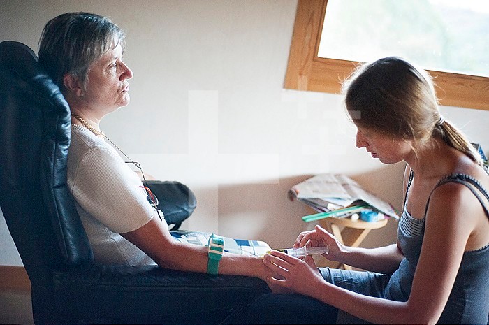 Reportage on an independent nurse in Haute-Savoie, France. Aline travels round her small mountain town every day to meet her patients. She also has a practice in town that she shares with two other colleagues. Aline injects a patient suffering from multiple sclerosis: a mix of homeopathy and vitamins.