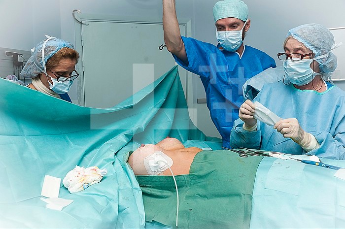 Reportage in the Mozart plastic surgery clinic in Nice, France. Fitting breast implants using the round block technique. The operation is finished: redon?s drain is in place and suction the last drops of blood around the implant.
