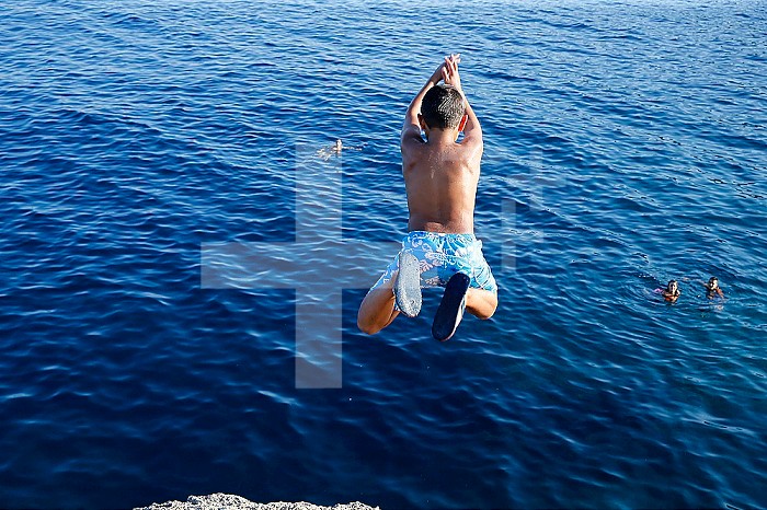 9-year-old boy diving into the sea.
