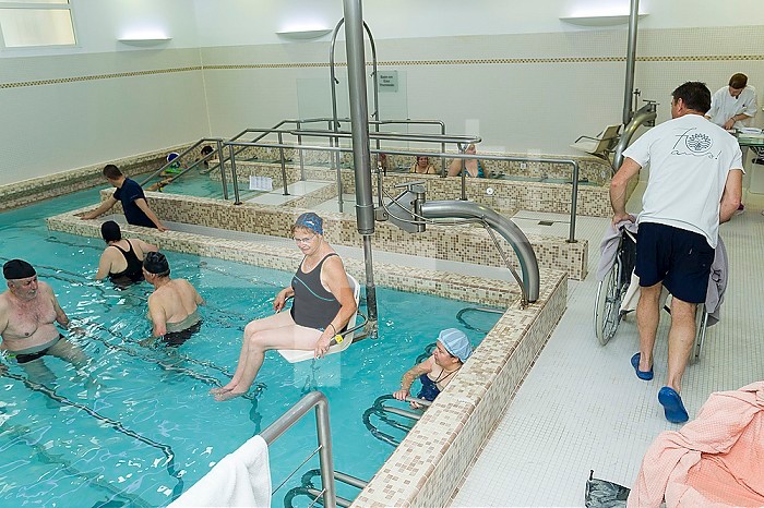 Reportage at the thermal baths in Lamalou-les-Bains, France. Reception area in the Leroy Pavilion, care service devoted to neurological disorders. The hydrotherapist uses the hydraulic seat.