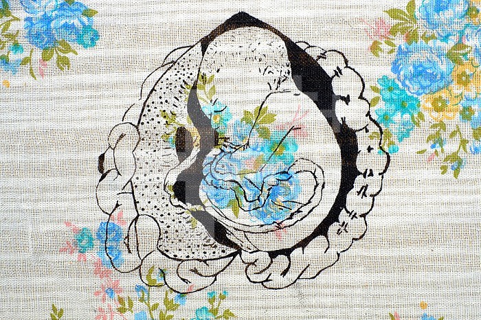 Screen print on flowery paper illustrating an in utero foetus.